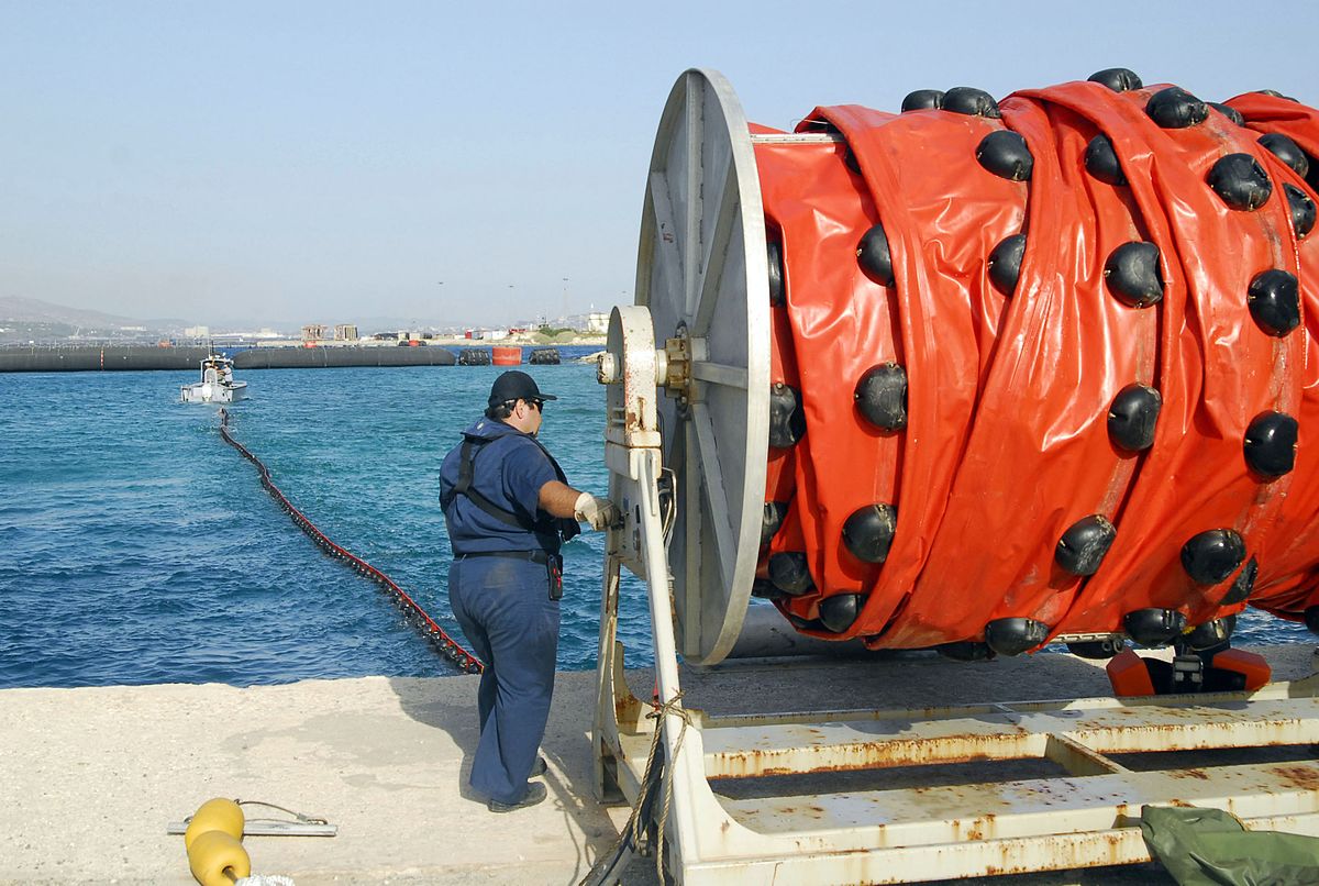 A civilian employee assigned U.S. Souda Bay Port Operations deploys hydraulic-powered boom reel during drill to test procedures contain recover oil during a spill, Crete, Greece, July 23, 2008.