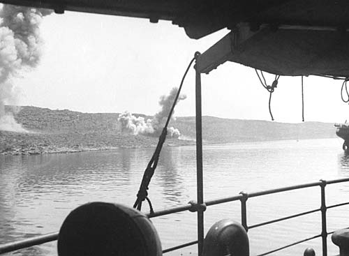 Smoke rising from troop positions ashore being bombed by German aircraft, Suda Bay, May 1941