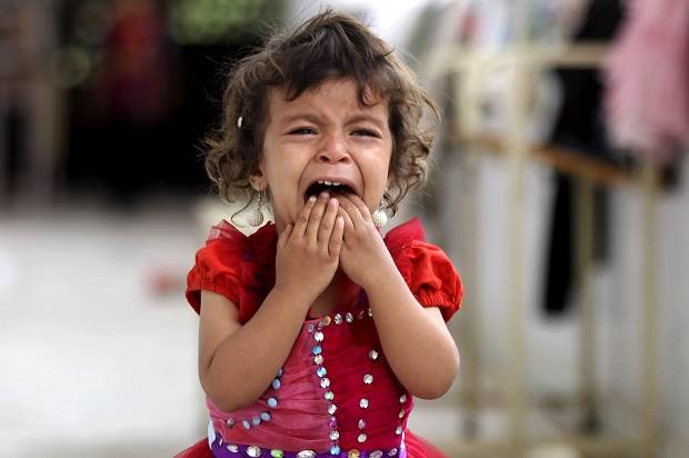 A girl cries as she walks onto the veranda at the yard of a school sheltering people displaced by Saudi-led air strikes on Yemen’s northwestern province of Saada, in the capital Sanaa