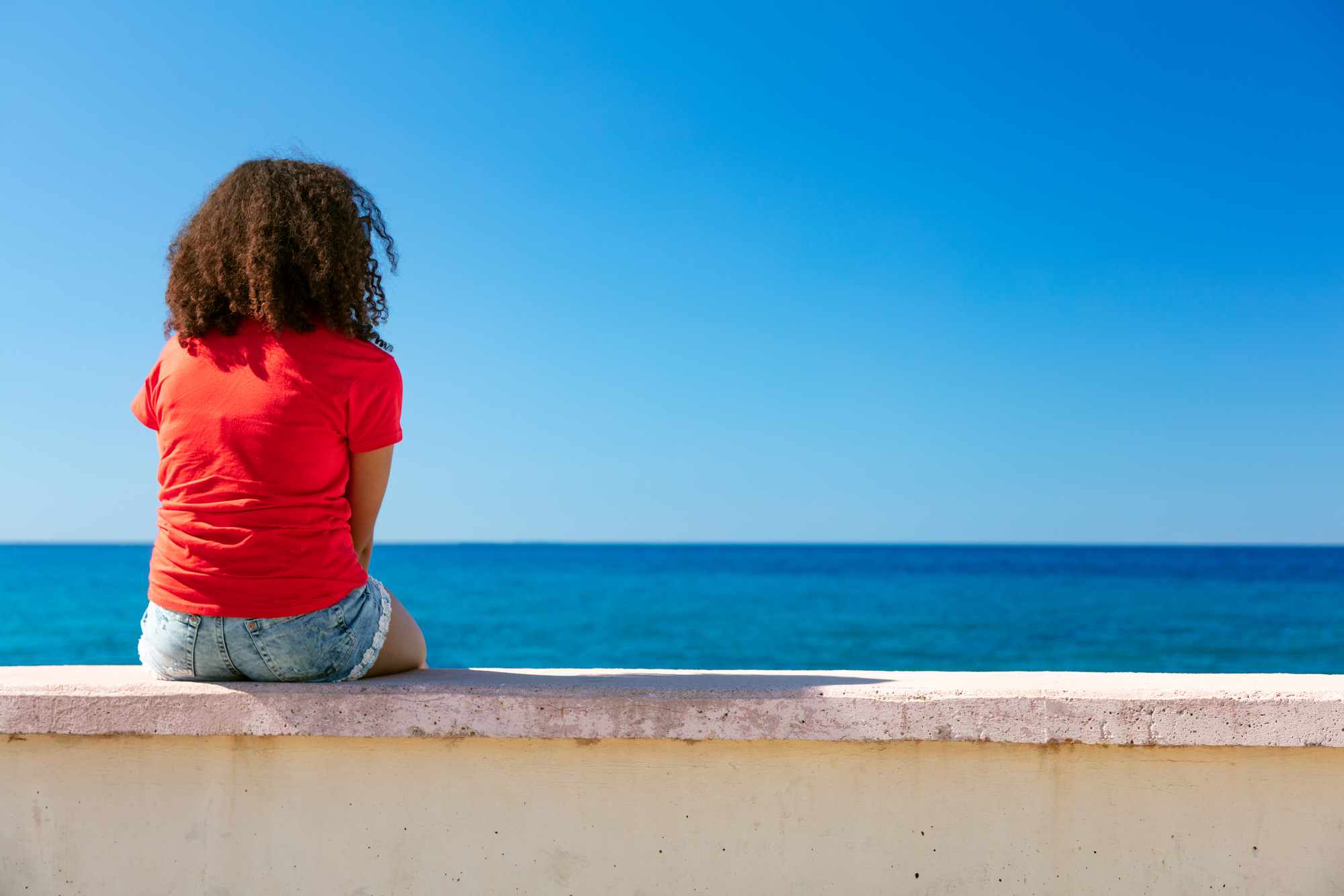 Young Woman Girl Teenager Sitting Wall Looking to Sea